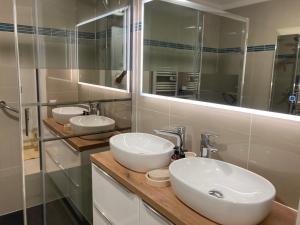 a bathroom with two sinks and a mirror at Appartement de standing Le Velvet Bay climatisé en bord de mer in Antibes