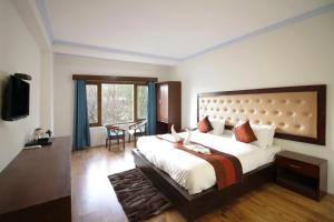 a bedroom with a large bed and a table at Hotel Ladakh Marvel Leh in Leh