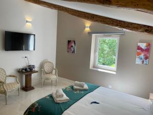 a bedroom with a bed with two towels on it at Domaine de Calypso & Suites - Adult Only in Auriol