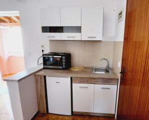 a small kitchen with a microwave and a sink at VILLA ELENA in Ipsos