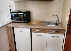 a small kitchen with a microwave and a sink at VILLA ELENA in Ipsos