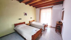 a bedroom with two beds and a window at VILLA ELENA in Ipsos