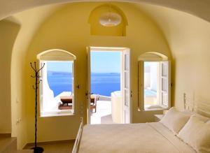 a bedroom with a bed and a view of the ocean at Grand Canava in Oia