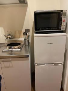 a microwave oven sitting on top of a refrigerator at W&J Dream Stay in Osaka