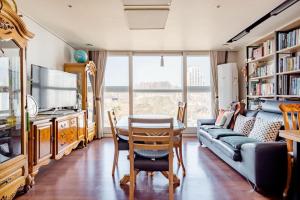 ein Wohnzimmer mit einem Tisch und einem Sofa in der Unterkunft Sky Cozy House in Seoul