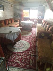 uma grande sala de estar com sofás e uma mesa em Immeuble chakir em Meknès