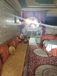 een kamer met een bank en een bed erin bij Immeuble chakir in Meknès