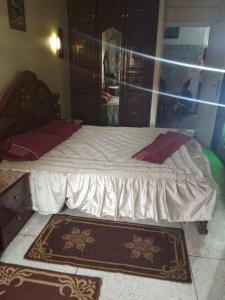 a bedroom with a large bed with a mirror at Immeuble chakir in Meknès