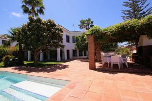a house with a patio and a swimming pool at TESS Villa Los Monteros in Alhaurín de la Torre