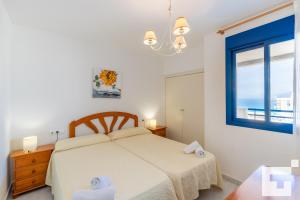 biała sypialnia z łóżkiem i oknem w obiekcie APCOSTAS Turquesa Playa - Calpe w mieście Calpe