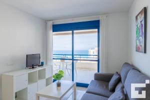 salon z kanapą i widokiem na ocean w obiekcie APCOSTAS Turquesa Playa - Calpe w mieście Calpe