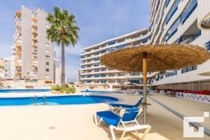 basen z 2 krzesłami i parasolem w obiekcie APCOSTAS Turquesa Playa - Calpe w mieście Calpe