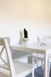 een wit bureau met een stoel en een cactus bij Værelse i rolig villakvarter, central beliggenhed in Odense