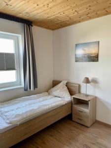 Schlafzimmer mit einem Bett, einem Tisch und einem Fenster in der Unterkunft Altefähr in Altefähr