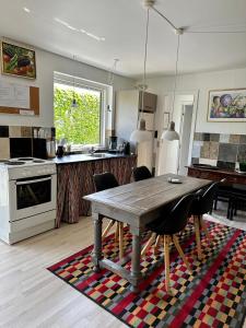 a kitchen with a wooden table and some chairs at Anne Just's Havehotel in Blokhus