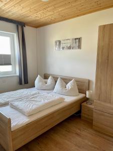 a bedroom with a bed with white sheets and pillows at Altefähr in Altefähr