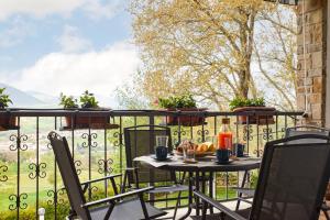 una mesa y sillas en un balcón con vistas en Villa Belveder - Piscina esclusiva, Parco e Panorama, en Castelraimondo