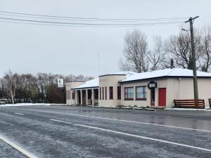 a row of buildings with snow covered roofs on a street at The Garston Lodge in Garston