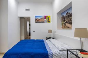 a bedroom with a blue bed in a white room at Stradivari Suite Roma in Rome