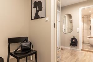 a bathroom with a black chair and a mirror at Scandinavian apartment with 2 bedrooms and terrasse - close to Storo Storsenter and all public transport in Oslo