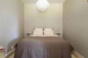 a bedroom with a bed with a gray blanket at Scandinavian apartment with 2 bedrooms and terrasse - close to Storo Storsenter and all public transport in Oslo