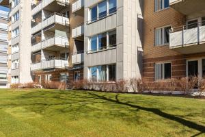 a large building with a grassy yard in front of it at Scandinavian apartment with 2 bedrooms and terrasse - close to Storo Storsenter and all public transport in Oslo