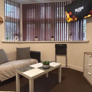 a living room with a couch and a table at Bv Charming Studio with Free Private Parking, 10 Minutes from Town Centre in Huddersfield