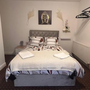 a bedroom with a large bed with a mask on the wall at Bv Charming Studio with Free Private Parking, 10 Minutes from Town Centre in Huddersfield
