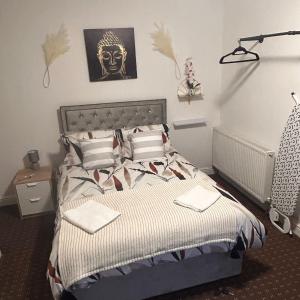 1 dormitorio con 1 cama con máscara en la pared en Bv Charming Studio with Free Private Parking, 10 Minutes from Town Centre, en Huddersfield