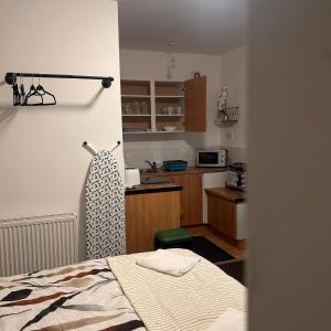 a bedroom with a bed and a kitchen with a microwave at Bv Charming Studio with Free Private Parking, 10 Minutes from Town Centre in Huddersfield