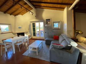 uma sala de estar com um sofá e uma mesa em Il Casale di B em Acilia