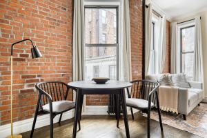 a table and chairs in a room with a brick wall at Nolita 1br w wd nr New Museum NYC-1037 in New York