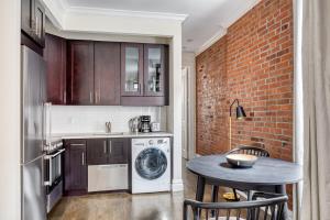 a kitchen with a washing machine and a table with chairs at Nolita 1br w wd nr New Museum NYC-1037 in New York