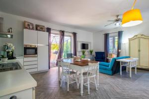 cocina y sala de estar con mesa y sillas en Guest House Abbacurrente, en Platamona