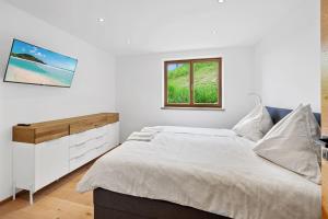 a white bedroom with a bed and a window at Luxus Chalet Moritz in Glanz an der Weinstraße