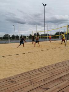 a group of people playing a game of volleyball on a court at Activités Et Nature Appartement in Vignot