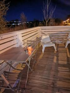 a table and chairs on a deck at night at Activités Et Nature Appartement in Vignot