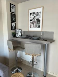 uma mesa num quarto com uma cadeira e fotografias na parede em Le Bristol em Cannes