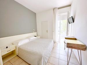 a white bedroom with a bed and a window at Aura Living Hotel in Rimini