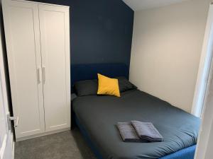 a bedroom with a bed with a yellow pillow and two towels at Ayresome House in Middlesbrough
