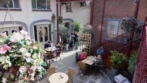 a group of people sitting at tables in a courtyard at Portland Mews - 3 Bed Holiday Home By Premier Serviced Accommodation in Leek