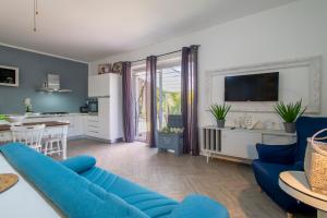 a living room with a blue couch and a kitchen at Guest House Abbacurrente in Platamona