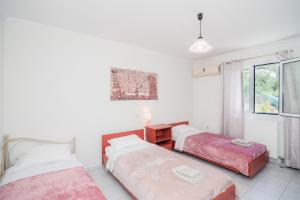 1 Schlafzimmer mit 2 Betten und einem Fenster in der Unterkunft Anna Maria house in Perama