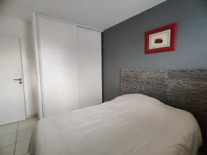 sypialnia z białym łóżkiem i ceglaną ścianą w obiekcie Le Village w Marsylii