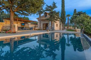 a house with a swimming pool in front of a house at Sunshine - Fairytale Countryside Villa by etouri in Rethymno
