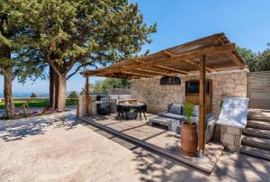 a patio with a table and a grill and a kitchen at Sunshine - Fairytale Countryside Villa by etouri in Rethymno