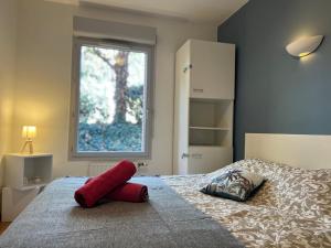 Un dormitorio con una cama con un objeto rojo. en T3 Centre ville avec Terrasse + Parking, en Toulouse 7 fotos más