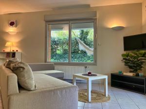 Una sala de estar con un sofá y una ventana. en T3 Centre ville avec Terrasse + Parking, en Toulouse