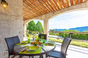 a table and chairs on a patio with a view at VILLA ROCHE GRISE - Berre-les-Alpes in Berre-des-Alpes