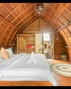ein Schlafzimmer mit einem großen weißen Bett in einem Zimmer in der Unterkunft Umah lumbung bedugul in Bedugul